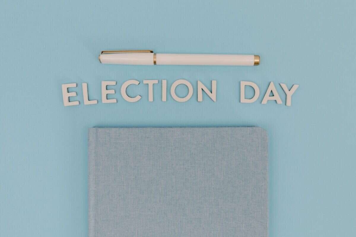 Photo by Tara Winstead Blue notebook and pen against a light blue background reading 'Election Day', ideal for campaign themes.